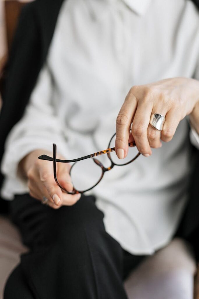 pexels-photo-4098340 Close-up of a woman holding glasses, symbolizing thought and professionalism.